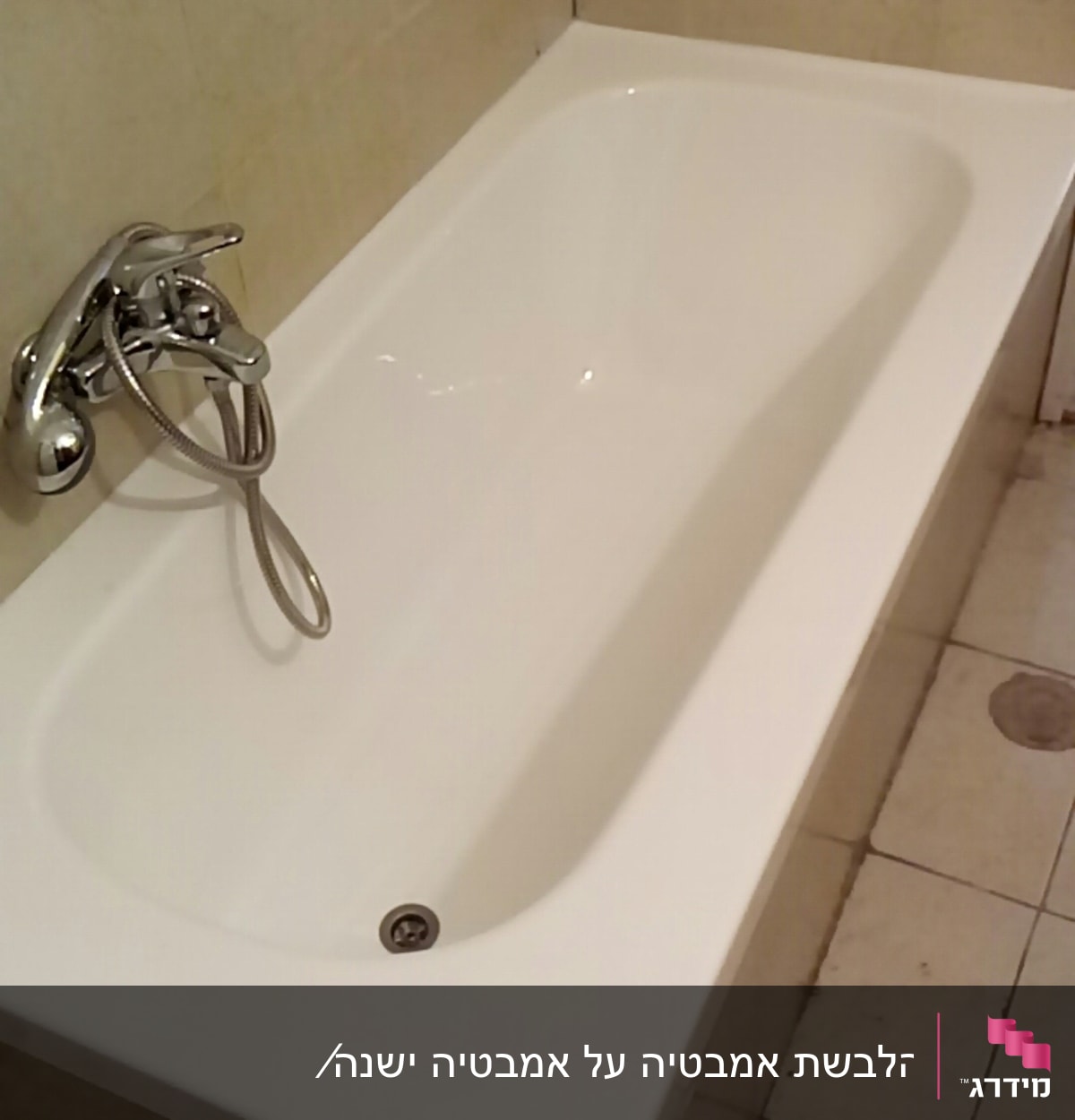 אמבטיה לבנה עם ברז כרום על קיר אריחים